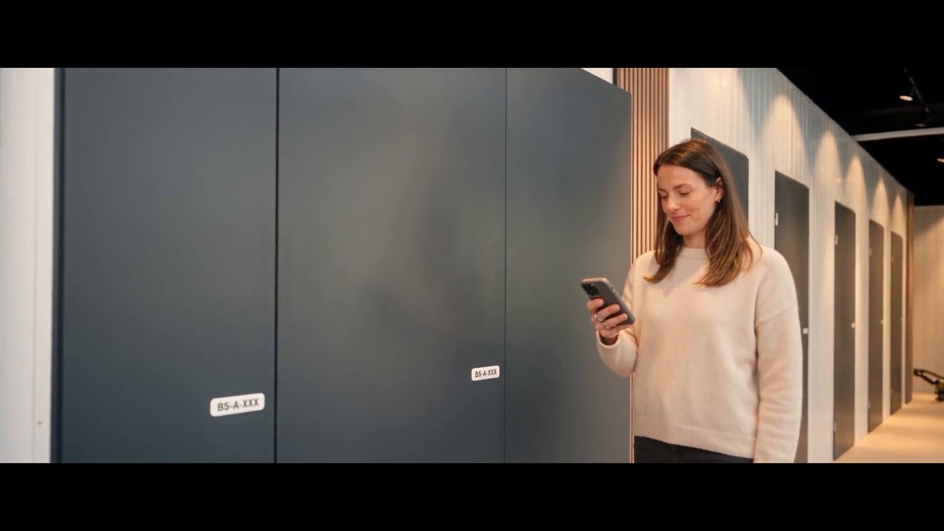 Frau öffnet ihre Lagerbox per App in einem BookaBox-Store
